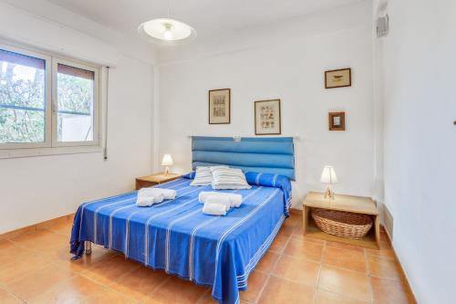 una camera da letto con un letto blu e asciugamani di Scopello Flat with Panoramic Courtyard and Parking a Scopello