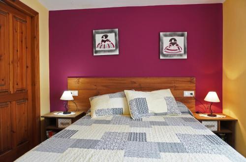 a bedroom with a purple wall and a bed at Casa El Cuatro in Beceite