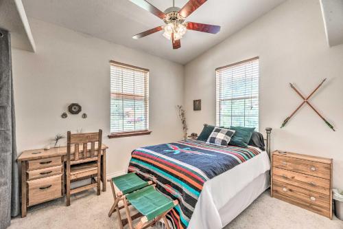 een slaapkamer met een bed, een bureau en een plafondventilator bij Charming Cloudcroft Cabin with Deck and Mtn Views in Cloudcroft