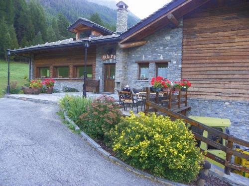 a house with a table and chairs in front of it at Hotel Les Granges in La Thuile