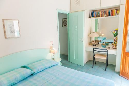 a bedroom with a bed and a desk with a chair at Acquamarina guest house in Marettimo