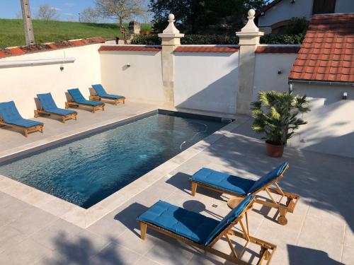 una piscina con tumbonas y una piscina en Hotel La Croix De Vernuche en Varennes Vauzelles
