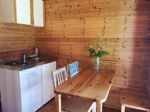 a kitchen with a wooden table and chairs and a sink at Tika Farmstay in Kõrkvere