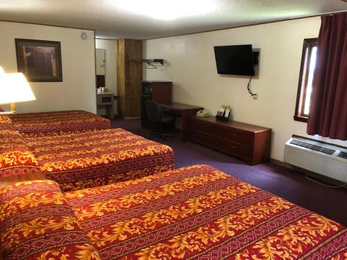 a hotel room with two beds and a desk at Budget Host Inn - Emporia in Emporia