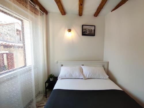 a small bedroom with a bed with a window at Lighthouse.Izola in Izola