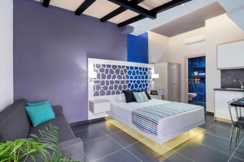 una camera con un letto bianco e un divano di El Mare Seaside Retreats - Bespoke Luxury Getaways a Limenaria