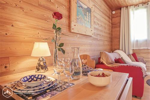 a dining room with a table with wine glasses and a flower at Locations Berne Milesi in Lanslevillard