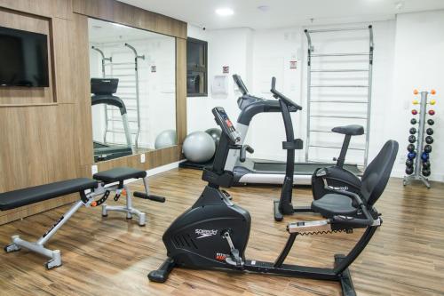 a gym with several exercise bikes and a flat screen tv at Bristol Imperatriz Maranhao in Imperatriz