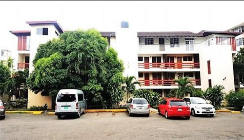 a group of cars parked in a parking lot in front of a building at The Mango Lodge in Kingston