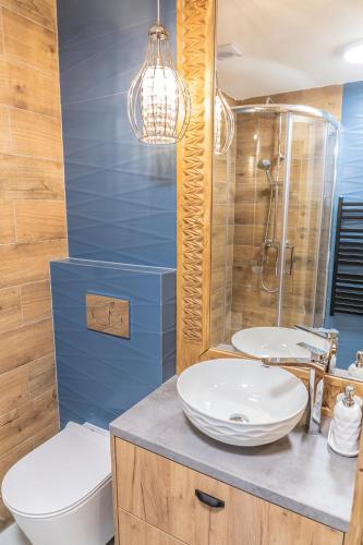 a bathroom with a sink and a toilet and a shower at Zbyszko Apartament Niebieski in Zakopane
