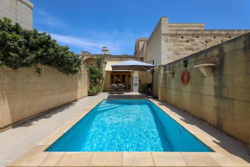 a swimming pool in the courtyard of a house at Superb Maltese Farmhouse with Private Pool in Victoria