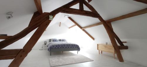 Schlafzimmer mit einem Bett im Dachgeschoss mit Holzbalken in der Unterkunft Maison Coeur de Ville - Spacieuse avec Terrasse in Déville-lès-Rouen