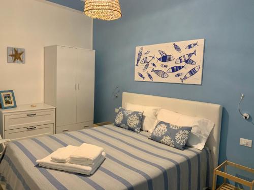 a bedroom with a bed with a blue wall at Bilocale “Cassiopea” vista Porto Nuovo in Lampedusa