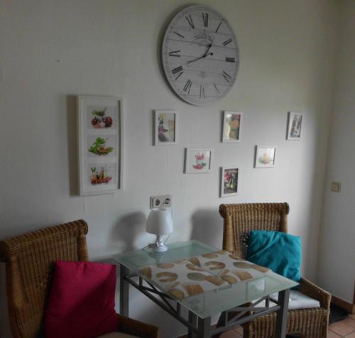 ein Esszimmer mit einem Tisch und einer Uhr an der Wand in der Unterkunft Ferienwohnung Oberkirchen in Schmallenberg