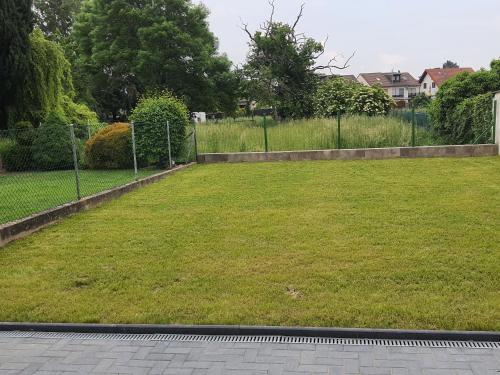 a yard with a fence and a grass field at Gäste Haus Am See in Düren - Eifel