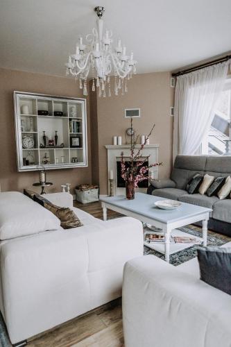 a living room with white furniture and a chandelier at Willa Sepia SPA in Wisła