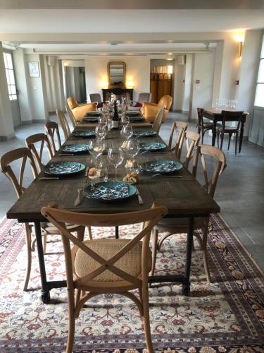 a long wooden table in a room with chairs at Domaine du Plessis in Le Plessis-Luzarches