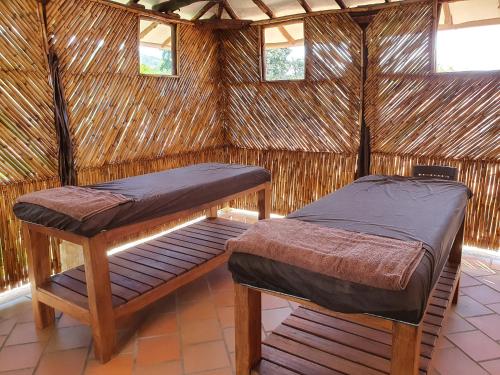 two beds in a straw hut with two windows at Hotel Campestre Ataraxia Barichara in Barichara