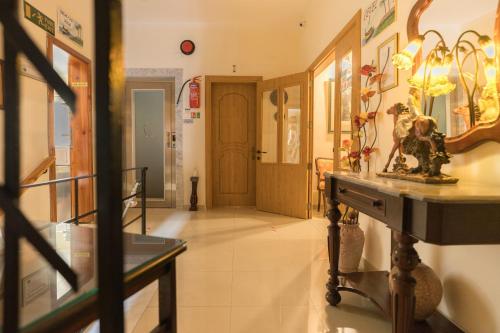 a hallway with a table with a vase on it at Lantern Guest House in Marsalforn