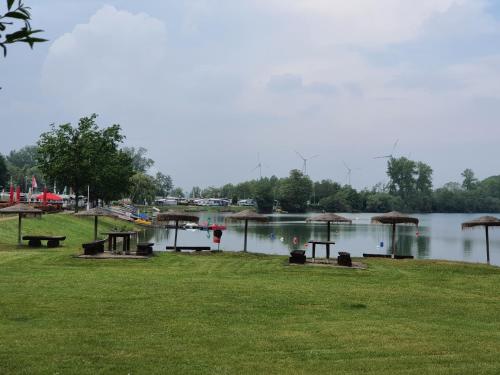 a body of water with picnic tables and a lake at Gäste Haus Am See in Düren - Eifel