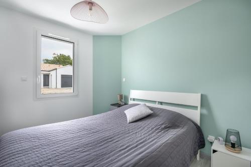 a white bedroom with a bed and a window at Maison moderne pour 7 personnes à Saint-Michel-Chef-Chef in Saint-Michel-Chef-Chef