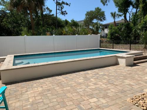 a swimming pool in a yard next to a fence at Beach Bum Paradise Edisto Beach with Pool in Edisto Island
