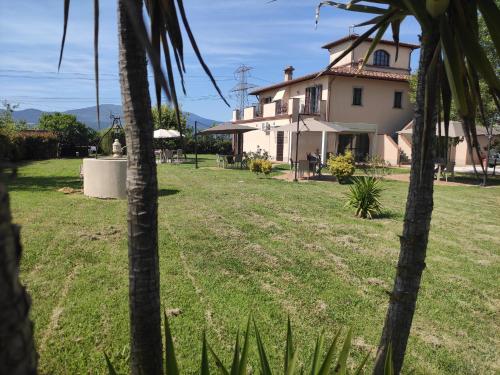 a house with a yard with palm trees at Il Casale di David in Pontedera
