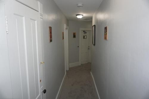 a hallway with white walls and pictures on the walls at Charlevoix House - The Northside in Charlevoix
