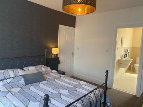 a bedroom with a large bed and a bathroom at Beautifully presented 6 bed 5 & a half bath house in Newcastle upon Tyne