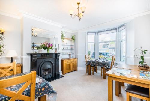 a living room with a fireplace and a table and chairs at Cragwood Guest House in Keswick