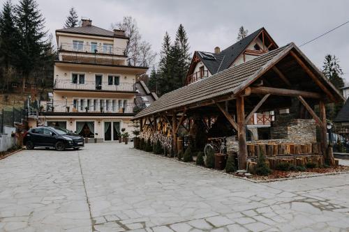 a building with a car parked in front of a house at Willa Sepia SPA in Wisła