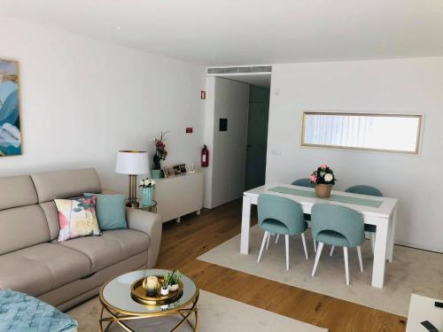 een woonkamer met een bank en een tafel en stoelen bij Apartment PURO HOMES in Aveiro