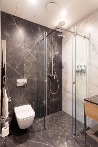 a bathroom with a toilet and a glass shower at Бутик-отель Status in Brest
