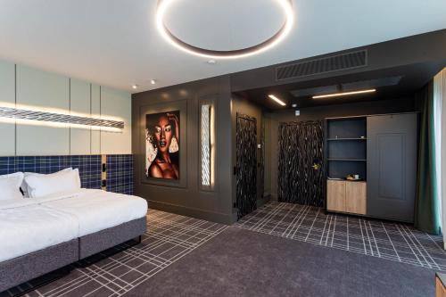 a bedroom with a bed and a painting on the wall at Бутик-отель Status in Brest