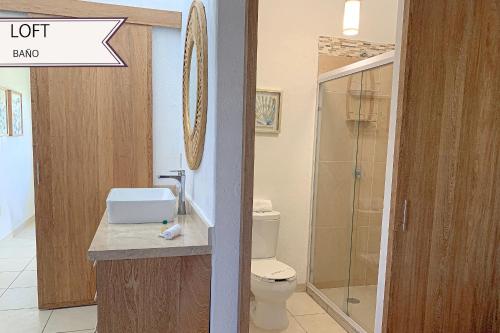 uma casa de banho com um WC e uma cabina de duche em vidro. em Condominios JAROJE em Santa Cruz Huatulco