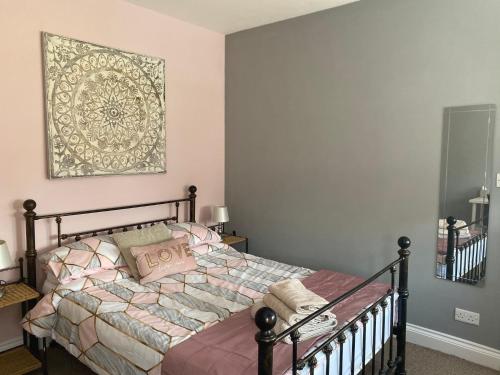 a bedroom with a bed with a picture on the wall at Beautifully presented 6 bed 5 & a half bath house in Newcastle upon Tyne