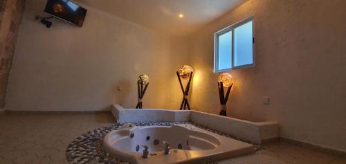a bathroom with a large tub and a window at Victoria Hotel y Spa in Ixtapan de la Sal
