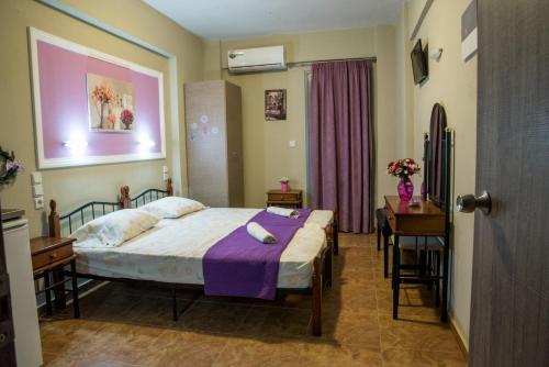 a bedroom with a bed and a table and a desk at Villa Rafailia in Olympic Beach
