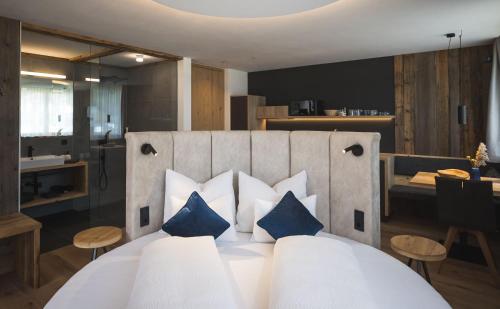 um quarto com uma cama branca e almofadas azuis em Schuischta Mountain Apartments em Sesto