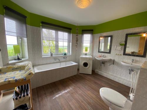 a large bathroom with a tub and two sinks and a bath tub at Ferienwohnung im Poolhaus mit Ostseeblick in Wittenbeck