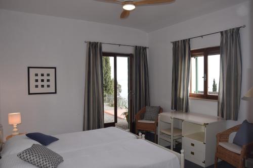 a bedroom with a bed and a desk and a window at Villa in the green, extraordinary silent position, great lake view in Garda