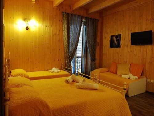 una camera con due letti, un divano e una TV di La Teresa B&B a Copertino