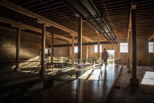a man walking through a building with a hallway at The Singular Patagonia Hotel in Puerto Natales