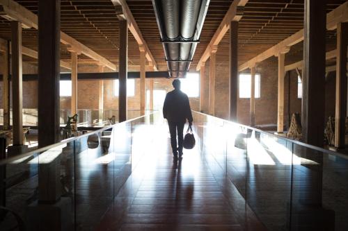 a man walking down a hallway in a building at The Singular Patagonia Hotel in Puerto Natales