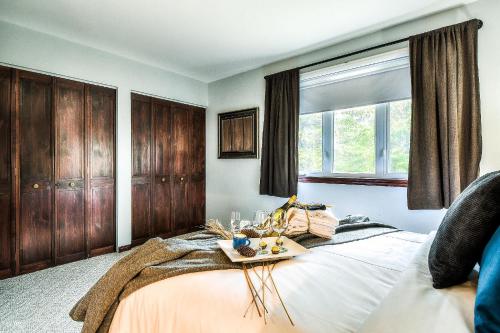 Un dormitorio con una cama con una bandeja de comida. en Townhouse On The Golf W Pool Access -aiglon 1717 en Mont-Tremblant