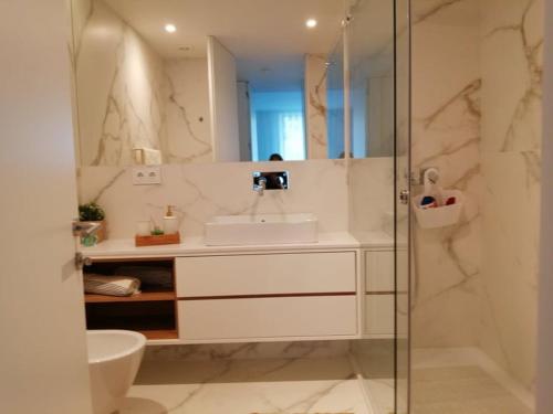 アヴェイロにあるApartment PURO HOMESの洗面台とガラスのシャワーを備えたバスルーム
