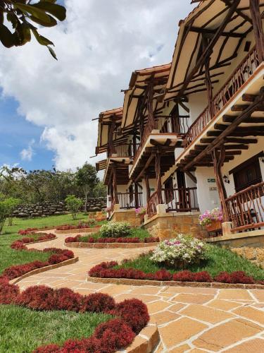 a house with a garden of flowers in front of it at Hotel Campestre Ataraxia Barichara in Barichara