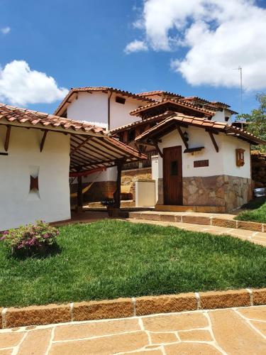 a house with a grass yard in front of it at Hotel Campestre Ataraxia Barichara in Barichara