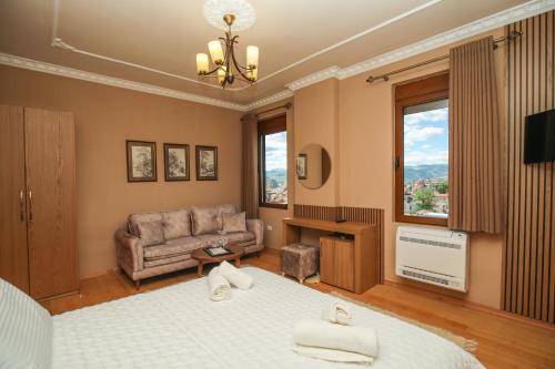- une chambre avec un lit, un canapé et une télévision dans l'établissement Vila 3 Korçë, à Korçë
