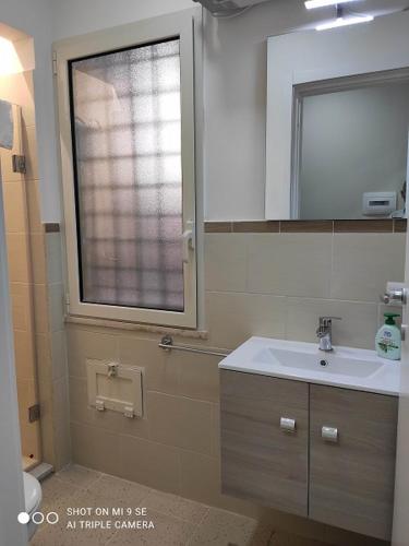 a bathroom with a sink and a window at Residenza Marvasi 10 in Caserta